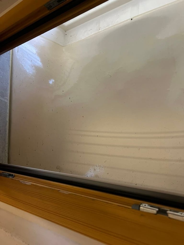 Dirty whiteboard with dust and marks on surface, mounted in wooden frame with black trim below